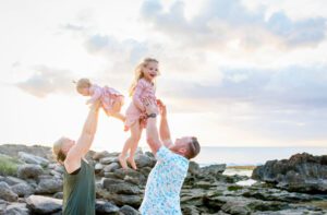 mom and dad holding girls in the air