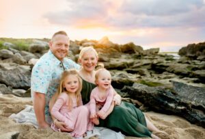 family smiling and sitting on the beach